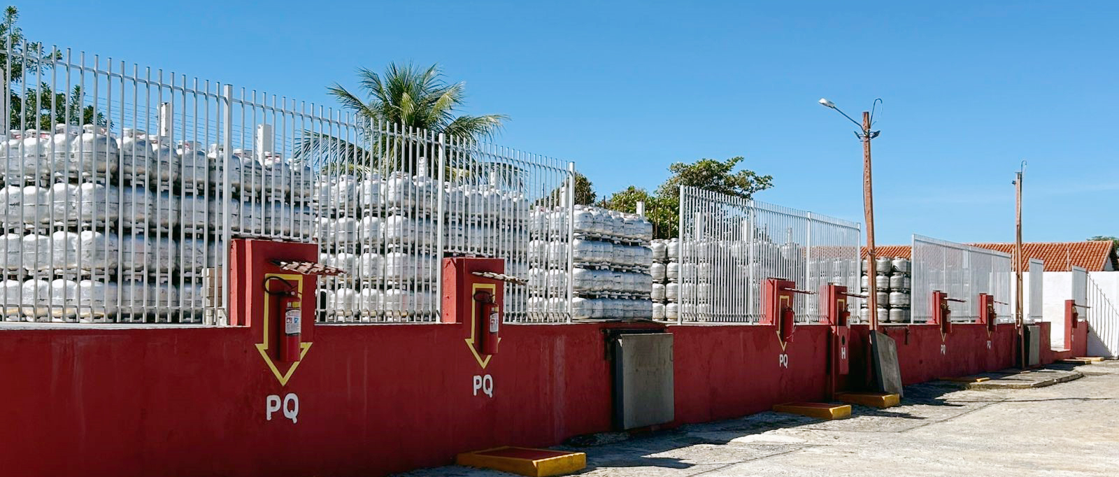 Botijões de gás GLP azuis e vermelhos organizados em depósito